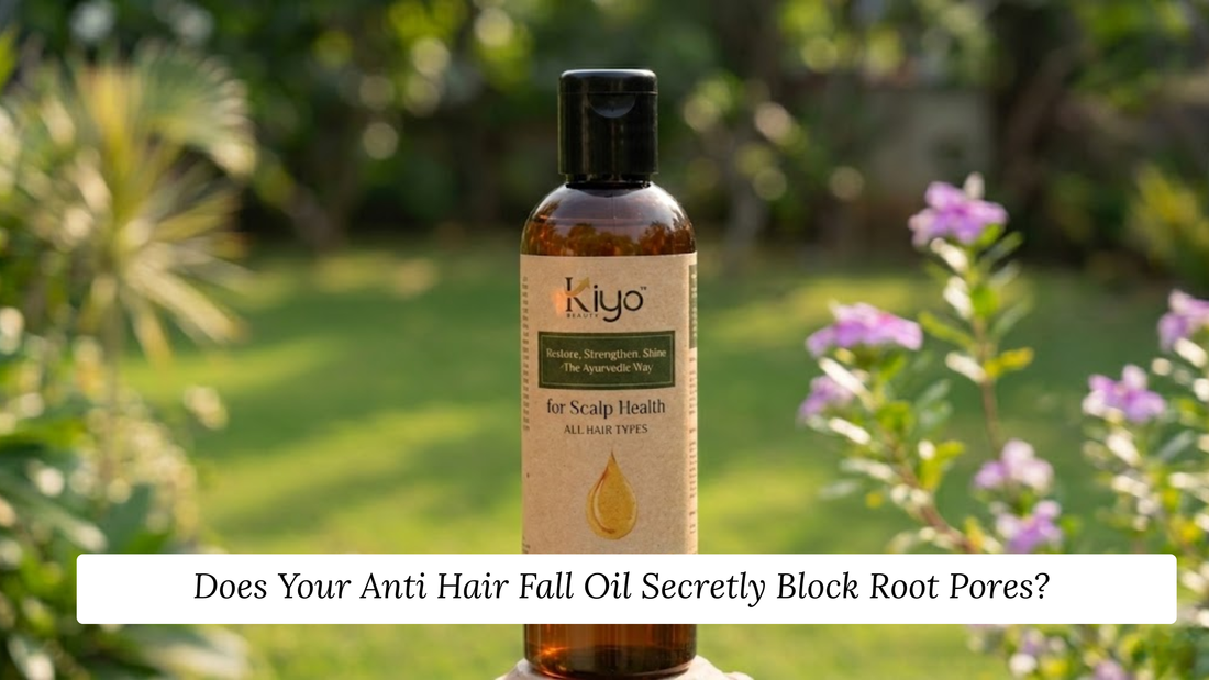 A 100ml amber glass bottle of Kiyo Beauty Ayurvedic Scalp Health Hair Oil centered against a soft, blurred green garden background with light pink flowers under warm natural daylight.