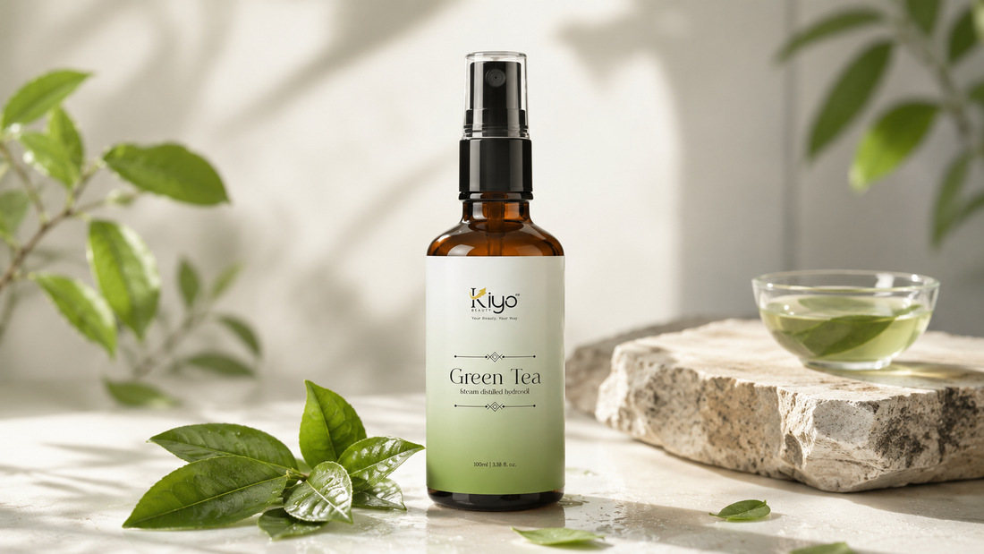 Green tea face mist bottle by Kiyo Beauty placed on a clean neutral surface with fresh green tea leaves and soft natural lighting, designed for oily skin and humid weather skincare routines.